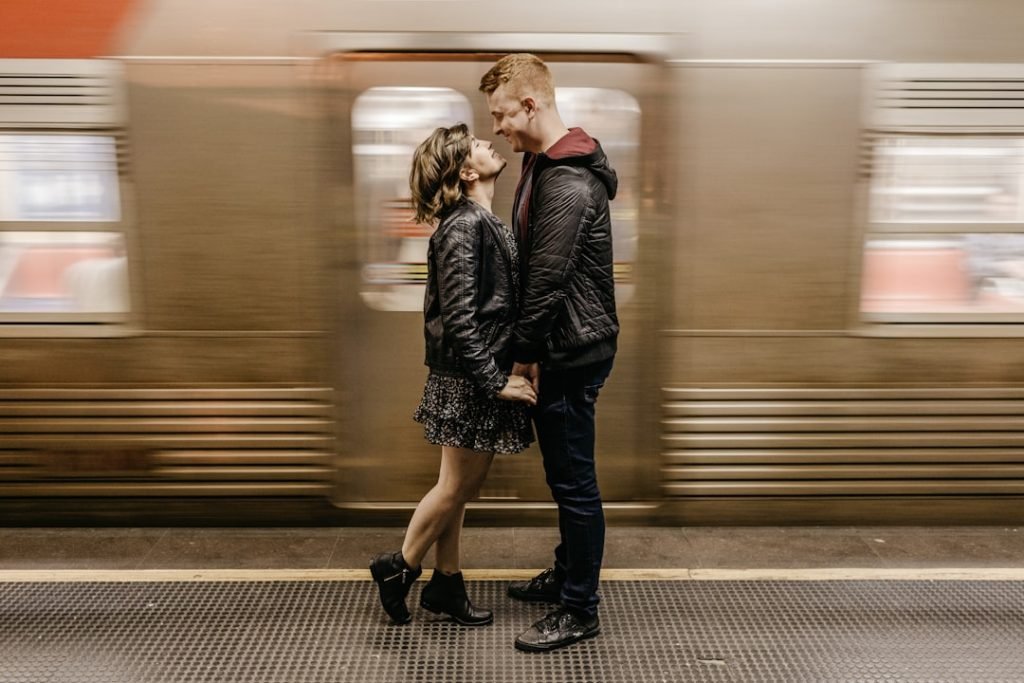 a-man-and-a-woman-standing-in-front-of-a-train-ntil4bwov1m